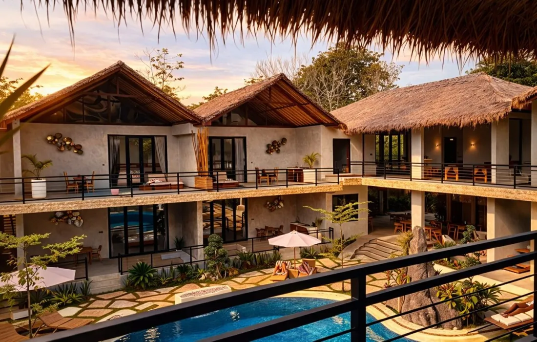 Bella Vida resort in Bali at sunset, with a pool and thatched villas
